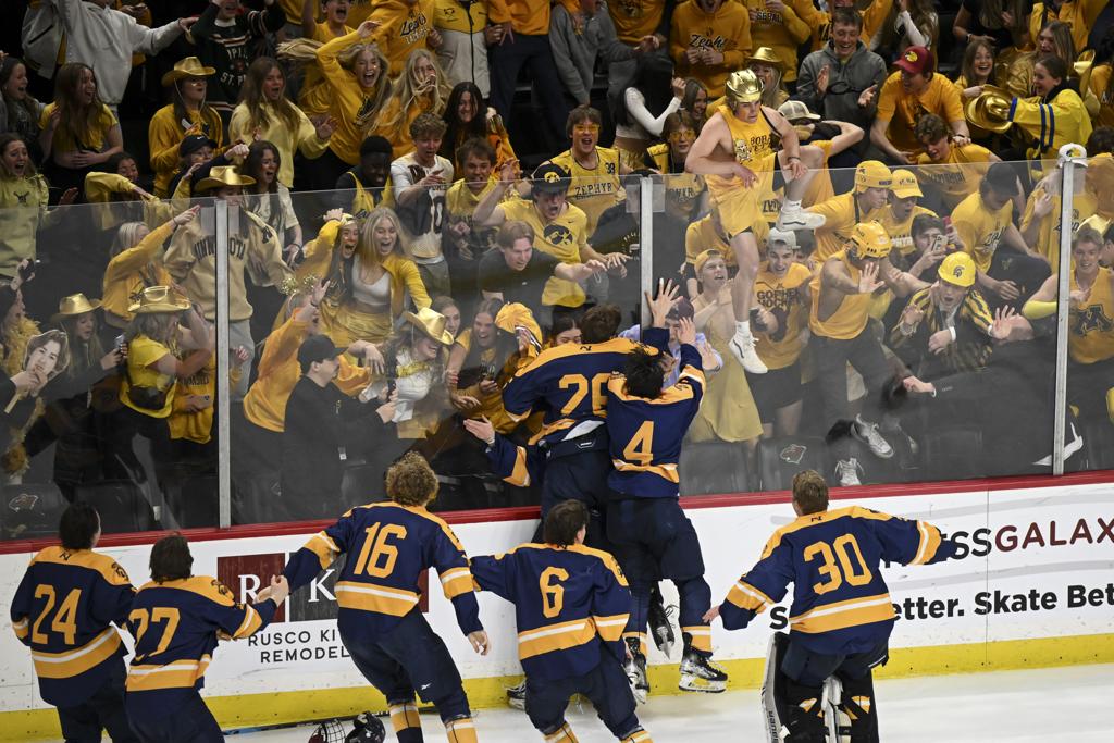 A fan climbs over the boards to celebrate with Mahtomedi after their double overtime win against Warroad Saturday, March 11, 2023 at the Xcel Energy Center in St. Paul, Minn. Warroad and Mahtomedi faced off in the Class 1A boys hockey state tournament championship game.       ] AARON LAVINSKY • aaron.lavinsky@startribune.com